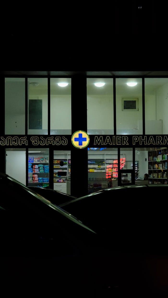 A pharmacy with illuminated signage at night, showcasing a modern urban exterior.